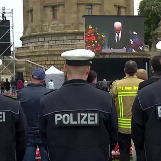 Drei Polizisten hören Winfried Kretschmanns Rede bei der Trauerfeier zu