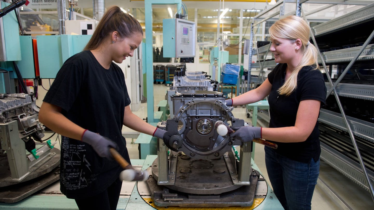 Zwei Ferienjobberinnen montieren im Daimler-Werk in Stuttgart einen Motorträger
