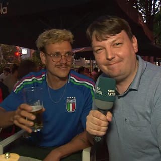 Reporter Frieder Kümmerer mit einem Fußballfan in Stuttgart