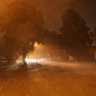 Starker Regen geht während eines Gewitters an einer Straßenkreuzung am Bodensee nieder.  
