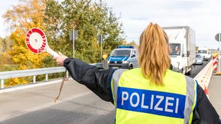 Eine Polizistin stoppt Autofahrer bei einer Grenzkontrolle.