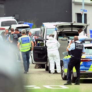 Polizei und Kriminaltechnik stehen in Albstadt beim abgesperrten Tatort, bei dem drei Tote und zwei Verletzte gefunden wurden.