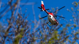 Ein Rettungshubschrauber fliegt über einen Wald. Am Donnerstagnachmittag ist ein Mann bei einem Drachenflug tödlich verunglückt. Die Unfallursache ist derzeit noch unklar.