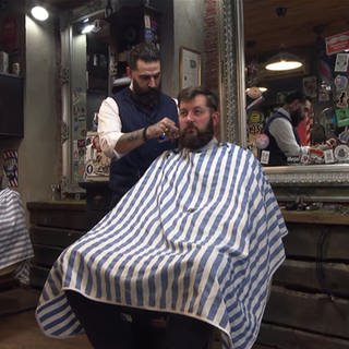 Mann bekommt einen neuen Haarschnitt im Barbershop