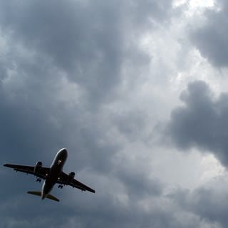 Maschine fliegt unter dunklen Wolken 