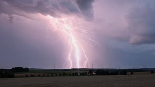 Ein Blitz zuckt am Mittwoch bei einem Sommergewitter am abendlichen Himmel über Bartholomä auf der Schwäbischen Alb.