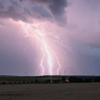 Ein Blitz zuckt am Mittwoch bei einem Sommergewitter am abendlichen Himmel über Bartholomä auf der Schwäbischen Alb.
