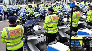 Polizeibeamte stehen bei einem Trauermarsch für einen im Dienst verunglückten Polizisten in einem Spalier.