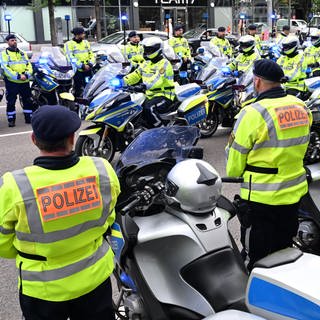 Polizeibeamte stehen bei einem Trauermarsch für einen im Dienst verunglückten Polizisten in einem Spalier.