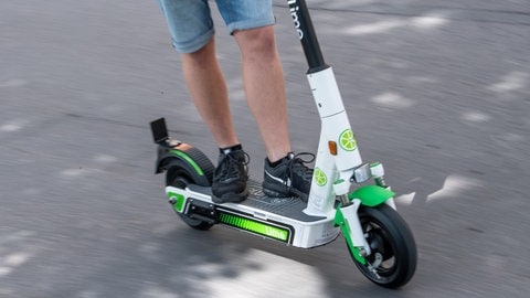 Ein Mann fährt in Stuttgart auf einem E-Roller.