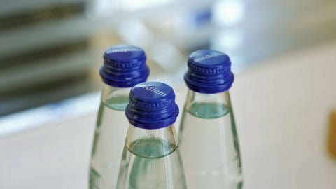 Auf einem Tisch stehen Flaschen mit Mineralwasser.