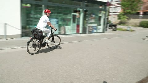 Eine Ärztin fährt mit dem Fahrrad zu einem Hausbesuch.