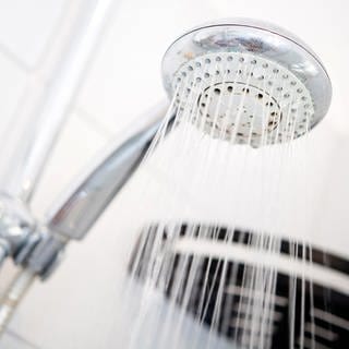 Wasser läuft aus einem Duschkopf (Symbolbild).