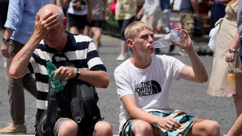 Symbolbild: Touristen erfrischen sich mit Wasser bei Hitze.