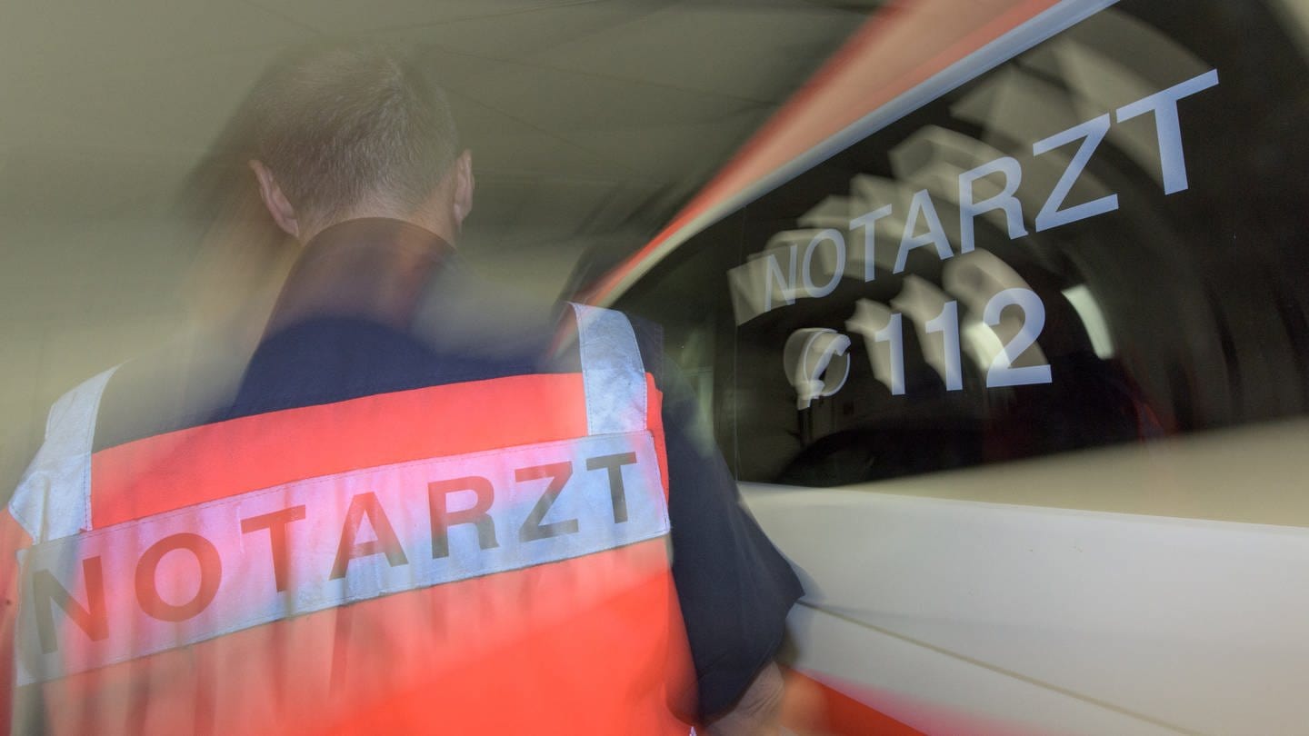 Ein Notarzt steht vor einem Einsatzfahrzeug. Die Bjön Steiger Stiftung aus Winnenden (Rems-Murr-Kreis) bereitet derzeit eine Verfassungsbeschwerde vor dem Bundesverfassungsgericht in Karlsruhe gegen das neue BW-Rettungsdienstgesetz vor.