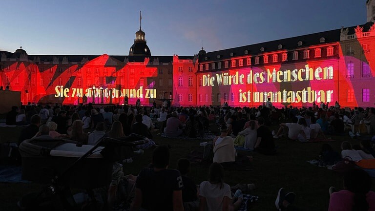 Auf dem Karlsruher Schloss ist bei den Schlosslichtspielen 2024 Artikel 1 des Grundgesetzes zu lesen: "Die Würde des Menschen ist unantastbar."