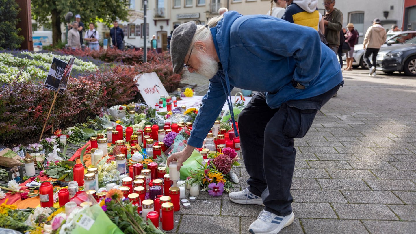 Nach dem Messeranschlag auf dem Stadtfest in Solingen stellt Philipp Müller, Hauptorganisator der Jubiläums-Feier, im Gedenken an die Opfer eine Kerze auf.