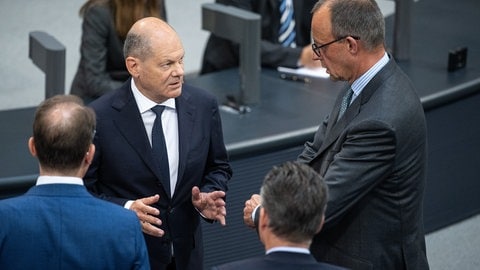 Bundeskanzler Olaf Scholz (SPD, li.) und Friedrich Merz, CDU-Bundesvorsitzender und Fraktionsvorsitzender der CDUCSU-Fraktion im Bundestag, unterhalten sich im Bundestag.