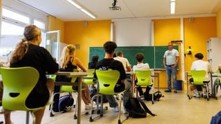 Der Klassenlehrer begrüßt eine neunte Klasse in der ersten Unterrichtsstunde des Jahres. 