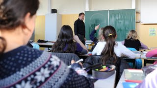 Ein Lehrer unterrichtet an einem Gymnasium in Marbach in Baden-Württemberg.