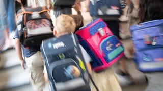 Schüler gehen während einer Einschulungsfeier der ersten Klasse zu ihrem Klassenraum. In den vergangenen Jahren stiegen die Kosten für Schulranzen, Stifte und Co. immer mehr. Für viele Eltern ist die Einschulung ihres Kindes ein finanzieller Kraftakt.