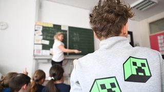 Schüler einer Grundschule arbeiten in einem Klassenzimmer an Mathematikaufgaben.