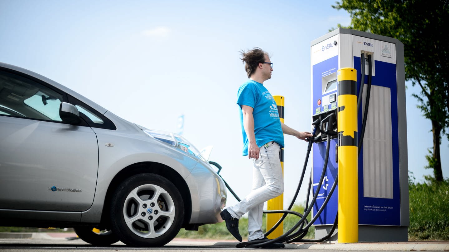 Ein Mann lädt sein Auto an einer Ladesäule für Elektroautos. In BW werden weniger Elektroautos zugelassen als erhofft.