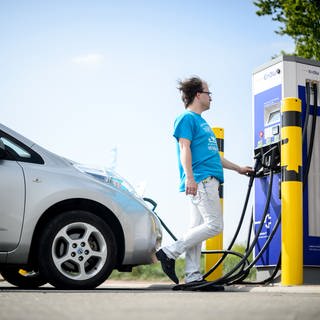 Ein Mann lädt sein Auto an einer Ladesäule für Elektroautos. In BW werden weniger Elektroautos zugelassen als erhofft.