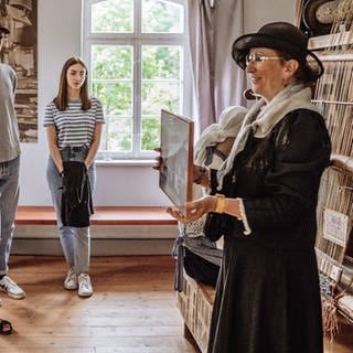 Eine Führerin erzählt einigen Leuten die Geschichte der Glashütte in Baiersbronn-Buhlbach, die vom 18. bis ins 19. Jahrhundert im Betrieb war. Beim Tag des offenen Denkmals kann man das Gebäude besuchen.