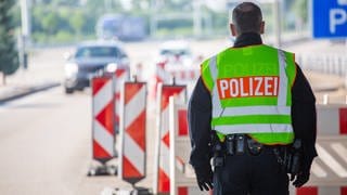 Ein Beamter der Bundespolizei steht am Grenzübergang Weil an der Autobahn A5.