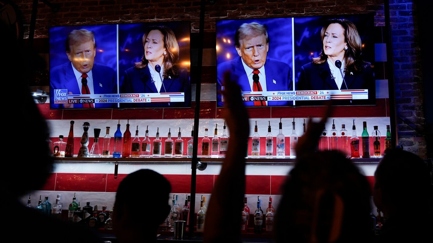 Besucher einer Bar verfolgen das TV-Duell zwischen den Präsidentschaftskandidaten Kamala Harris und Donald Trump im Fernsehen.