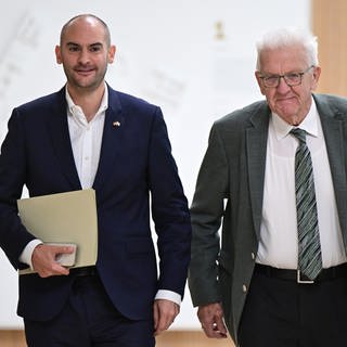 Danyal Bayaz (Grüne), Finanzminister von Baden-Württemberg, und Winfried Kretschmann (Grüne), Ministerpräsident von Baden-Württemberg, kommen gemeinsam zur Landes-Pressekonferenz im Landtag. Am Freitag hat sich die grün-schwarze Landesregierung auf einen Doppelhaushatsentwurf für 20252026 geeinigt.