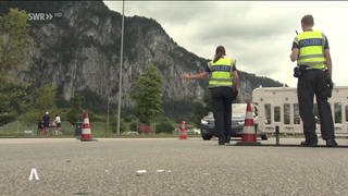 Zwei Polizisten stoppen Autos an der Grenze