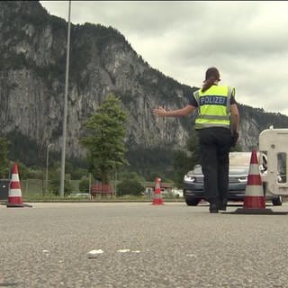 Zwei Polizisten stoppen Autos an der Grenze