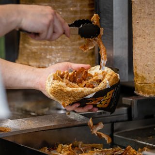 Ein Mitarbeiter einer Dönerbude legt Fleisch in einen Döner. Die Heilbronner CDU hat eine Dönerobergrenze für die Stadt gefordert.