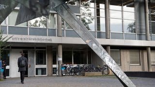 Studenten gehen in die Universitätsbibliothek der Universität Stuttgart.