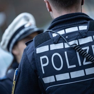 Eine Polizistin und ein Polizist stehen auf einer Straße (Symbolbild).