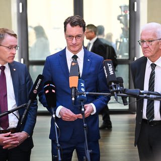 Hendrik Wüst (CDU, Mitte), Ministerpräsident von Nordrhein-Westfalen, Daniel Günther (CDU, links), Ministerpräsident von Schleswig-Holstein, und Winfried Kretschmann (Grüne, rechts), Ministerpräsident von Baden-Württemberg, geben vor der 1047. Sitzung des Bundesrats ein Statement.