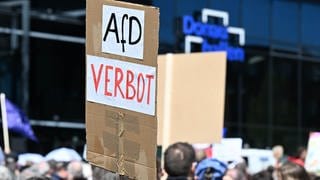 Gegner der Partei AfD demonstrieren mit Plakaten vor dem Versammlungsort des AfD Europa-Wahlkampfauftakts.