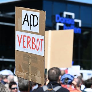 Gegner der Partei AfD demonstrieren mit Plakaten vor dem Versammlungsort des AfD Europa-Wahlkampfauftakts.