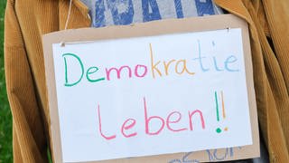 Schild mit Aufschrift "Demokratie leben!"