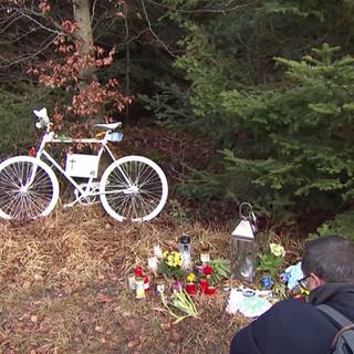 Gedenkort für verstorbenen Radfahrer mit Blumen und Fahrrad