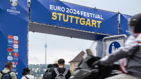 Menschen gehen am Aufbau des Public Viewing für die Fußball-Europameisterschaft in Deutschland auf dem Stuttgarter Schlossplatz vorbei.