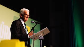 Winfried Kretschmann (Grüne), Ministerpräsident von Baden-Württemberg, steht auf der Bühne. Die Beliebtheit der Grünen ist laut BW-Trend um vier Prozentpunkte gesunken.