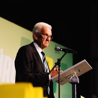 Winfried Kretschmann (Grüne), Ministerpräsident von Baden-Württemberg, steht auf der Bühne. Die Beliebtheit der Grünen ist laut BW-Trend um vier Prozentpunkte gesunken.