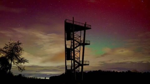 Der Aussichtsturm Heidengraben in Grabenstetten (Kreis Reutlingen) im Polarlicht. Die Polarlichter waren am Donnerstag (10.10.24) in Baden-Württemberg zu sehen.