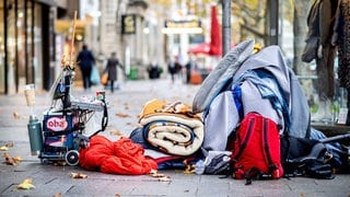 Die Habseligkeiten eines Obdachlosen liegen auf einem Bürgersteig in der Innenstadt. In Baden-Württemberg hat die Aktionswoche gegen Armut begonnen.