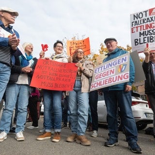 Menschen demonstrieren mit Schildern - Demo vor dem Sitz der Kassenärztlichen Vereinigung Baden-Württemberg (KVBW)