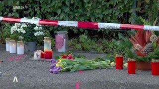 Kerzen und Blumen an einer Unfallstelle