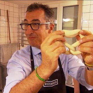 Cem Özdemir in einer Bäckerei beim Brezeln backen